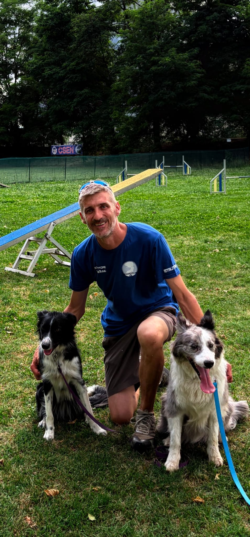 Andrea Polo con i suoi due border collie sul campo di agility del centro cinofilo DOG HOUSE